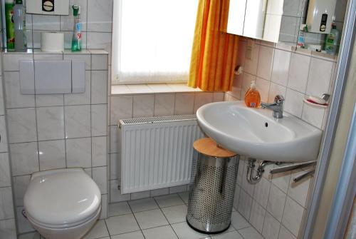 ein Bad mit einem Waschbecken und einem WC in der Unterkunft Haus Nordseeperle Whg.5 in Cuxhaven