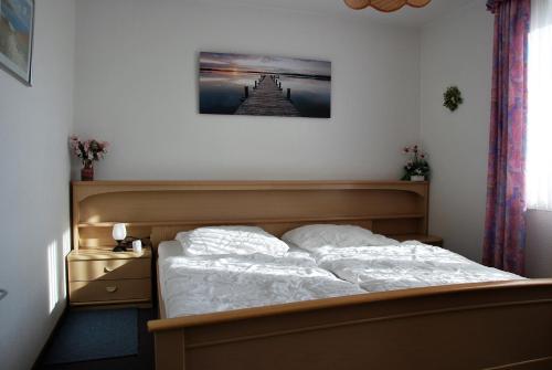 ein Schlafzimmer mit einem Bett und einem Bild an der Wand in der Unterkunft Haus Nordseeperle Whg.5 in Cuxhaven