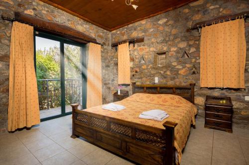 Un dormitorio con una cama y una pared de piedra. en Villa Livadia with Pool, close to Elafonissi famous Beach, en Livadia