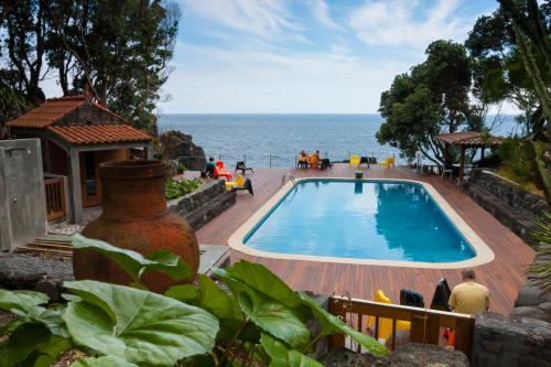 a swimming pool with the ocean in the background at Aldeia da Fonte Hotel in Lajes do Pico