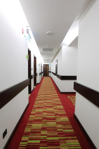 a corridor with a red carpet in a hallway at Corp Amman Hotel in Amman