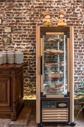 a display case with food in it next to a brick wall at Hotel Crasborn Thorn in Thorn