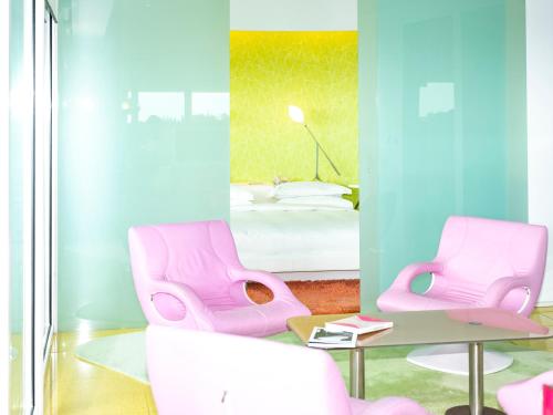 a room with two pink chairs and a bed at Semiramis in Athens
