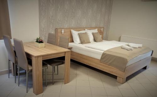 バラトンフレドにあるBlue Mediterran Apartment Houseのベッドルーム1室(ベッド1台、テーブル、テーブル、椅子付)