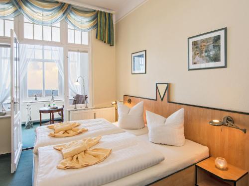 a bedroom with a large bed with white sheets at Strandvilla Imperator in Bansin