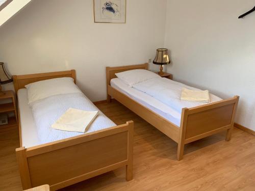 two twin beds in a room with a lamp at Hotel Jeong in Moers