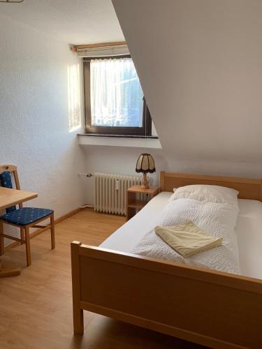 a bedroom with a bed and a table and a window at Hotel Jeong in Moers