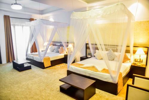 1 dormitorio con 2 camas con mosquiteras en Rice of Life by Tissa Inn, en Tissamaharama