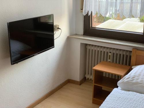 a bedroom with a flat screen tv on the wall at Hotel Jeong in Moers