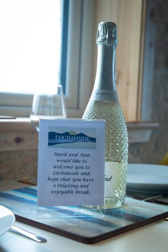 a bottle of water sitting on a table with a sign at Lochanside in Struan