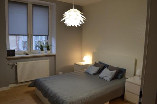 a bedroom with a bed and a chandelier at Apartament SZTOKHOLM in Białystok
