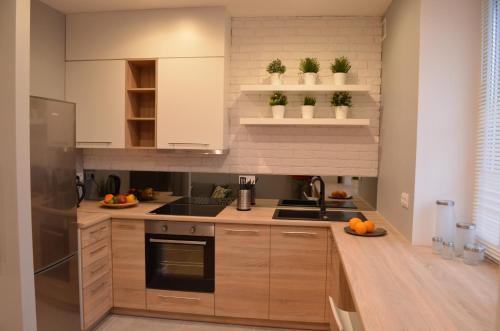 a kitchen with white cabinets and a stove top oven at Apartament SZTOKHOLM in Białystok