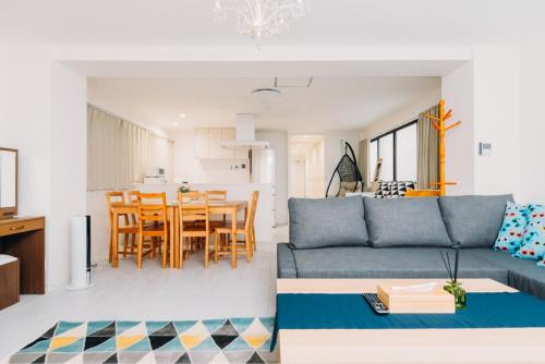 een woonkamer en een keuken met een bank en een tafel bij Higobashi AFP Apartment in Osaka