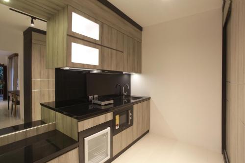 a kitchen with a black counter and a sink at Matahari Bungalow in Legian
