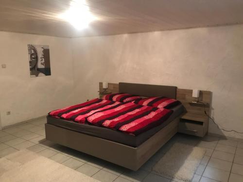 a bedroom with a bed with a red blanket on it at Obere Kellerstraße Haus 2 in Forchheim
