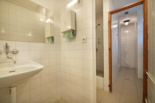 a white bathroom with a sink and a shower at EA Hotel Hrubá Skála in Hrubá Skála