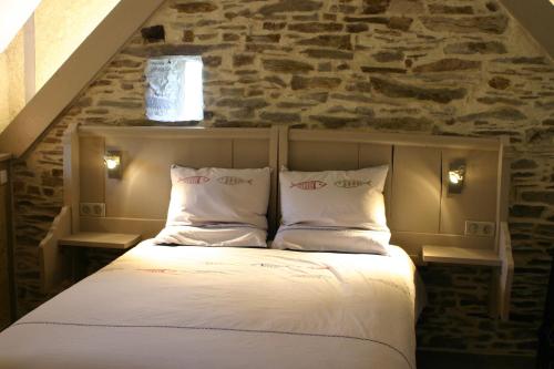 Cama en habitación con pared de piedra en Au gré du Marais - Chambres d'hôtes en Ancenis