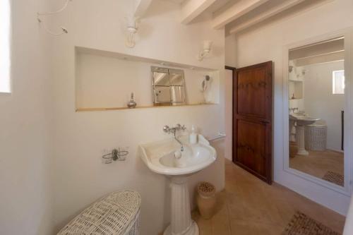 a white bathroom with a sink and a mirror at Can Toni Platera in Sant Francesc Xavier