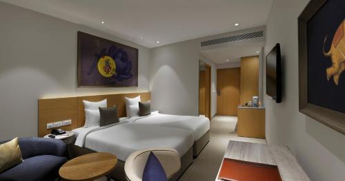 ドワルカにあるGinger Dwarkaのベッドとソファ付きのホテルルーム
