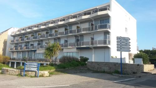 un bâtiment blanc avec un panneau de rue devant lui dans l'établissement studio résidence le sombreuil, à Quiberon