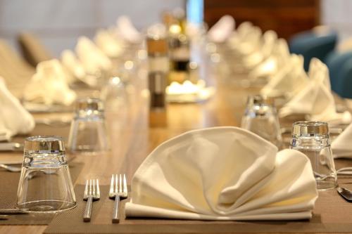 a table with white plates and forks and napkins at Radisson Hotel Sfax in Sfax
