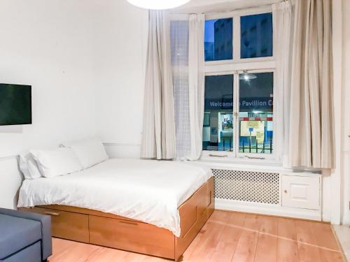 biała sypialnia z łóżkiem i oknem w obiekcie Knightsbridge Apartments w Londynie
