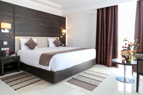 a bedroom with a large bed and a table at Radisson Hotel Sfax in Sfax