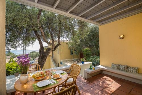 patio con tavolo e sedie di Pavlina Apartment By Hotelius a Barbati