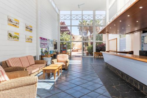 a lobby with couches and chairs in a building at Hotel Palia Don Pedro in Costa Del Silencio