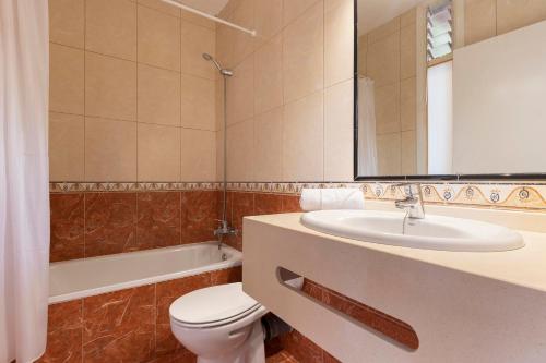 a bathroom with a sink and a toilet and a mirror at Hotel Palia Don Pedro in Costa Del Silencio