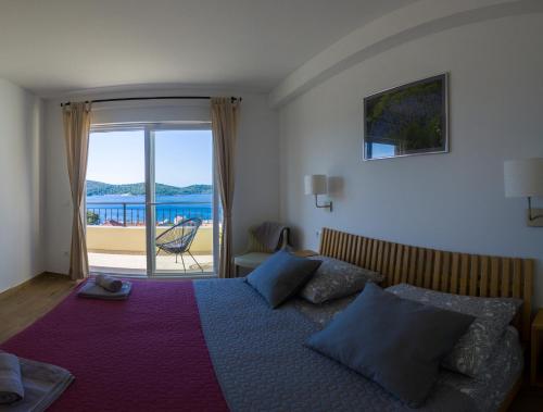 una camera con letto e vista sull'oceano di Apartment Sandra (2+2) with a breathtaking view a Vis