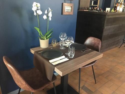 una mesa de madera con platos y copas de vino. en Au Wingenerhof, en Wingen-sur-Moder