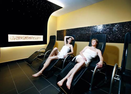 two women sitting in chairs on a train at Hotel Europa Fit Hévíz in Hévíz
