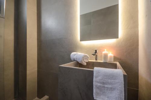 a bathroom with a sink with towels and a mirror at Villa Tranquillity in Kastraki Naxou