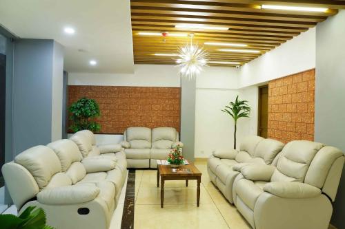 a living room with white couches and a table at Bhavanam Regency Guruvayoor in Guruvāyūr