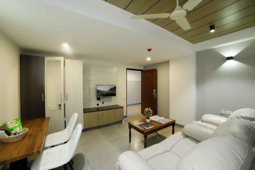 a living room with a white couch and a table at Bhavanam Regency Guruvayoor in Guruvāyūr