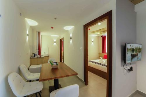 a room with a table and chairs and a bedroom at Bhavanam Regency Guruvayoor in Guruvāyūr