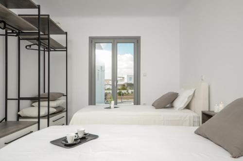 two beds in a room with a window at Villa Tranquillity in Kastraki Naxou