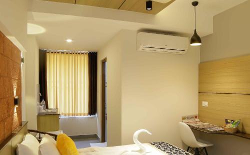 a bedroom with a bed and a desk and a window at Bhavanam Regency Guruvayoor in Guruvāyūr