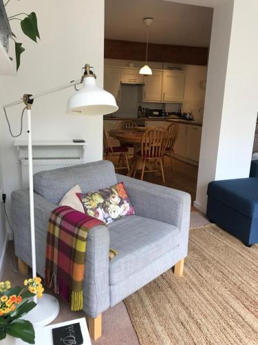 a living room with a couch and a kitchen at Coverdale in Lyme Regis