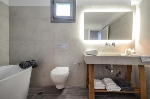 a bathroom with a sink and a toilet and a mirror at Villa Tranquillity in Kastraki Naxou