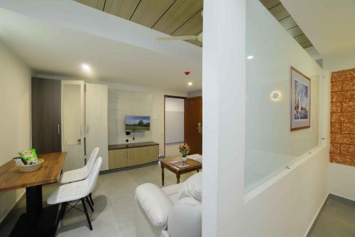 a living room with a white couch and a table at Bhavanam Regency Guruvayoor in Guruvāyūr