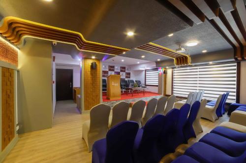 a conference room with blue chairs and a podium at Bhavanam Regency Guruvayoor in Guruvāyūr