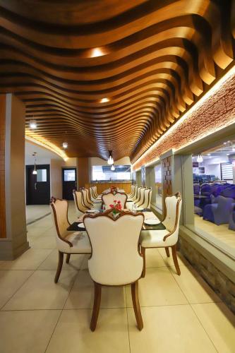 a dining room with a long table and chairs at Bhavanam Regency Guruvayoor in Guruvāyūr