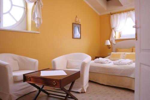 1 Schlafzimmer mit einem Bett, 2 Stühlen und einem Tisch in der Unterkunft Dom Pugetów in Krakau