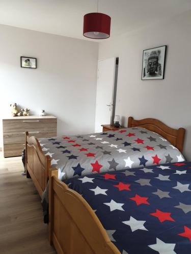 Un dormitorio con una cama con estrellas rojas y blancas. en APPARTEMENT ROUGE, en Saint-Anthème