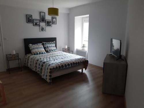 Saint-AnthèmeAPPARTEMENT ROUGE的卧室里有一张床和一台电视机