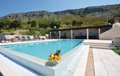 a swimming pool with a bowl of fruit on the edge at Villa View 4 You in Podstrana