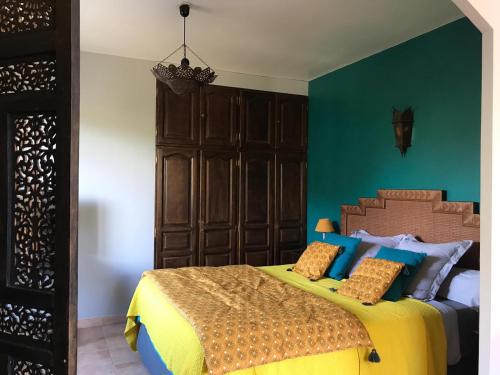 - une chambre avec un lit jaune et bleu dans l'établissement Les Jardins d'Holi appartement proche Uzès, à Garrigues-et-Sainte-Eulalie