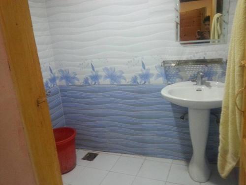 uma casa de banho com um lavatório e uma parede azul e branca em Snowland Hotel em Murree